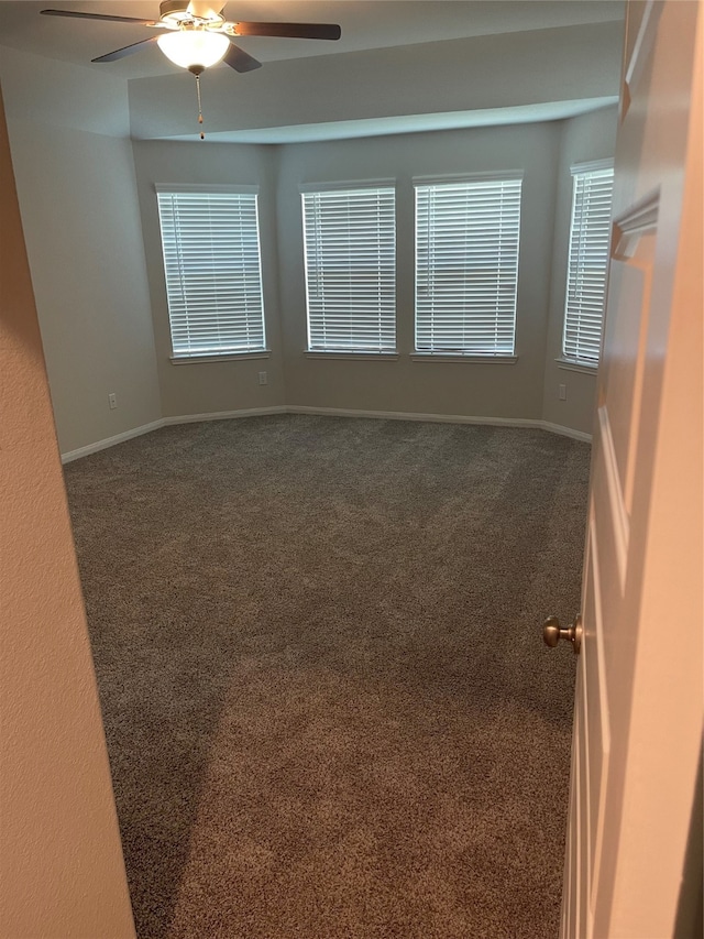 carpeted spare room with ceiling fan