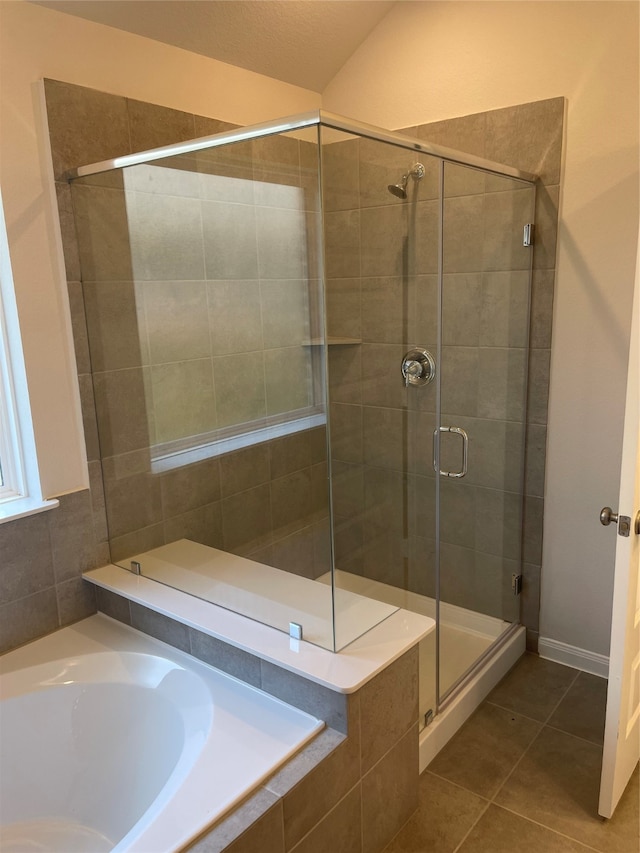 bathroom featuring tile walls, tile flooring, and separate shower and tub