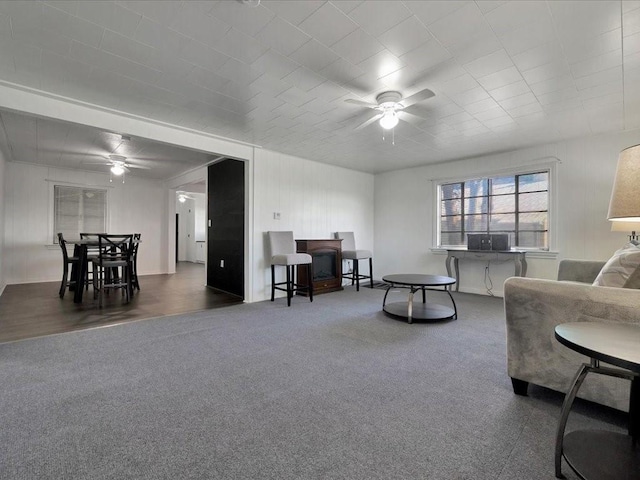 carpeted living room with ceiling fan