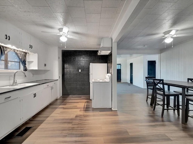 kitchen featuring white cabinetry, sink, and light wood-type flooring