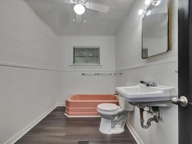 bathroom with toilet, a bathing tub, and hardwood / wood-style floors