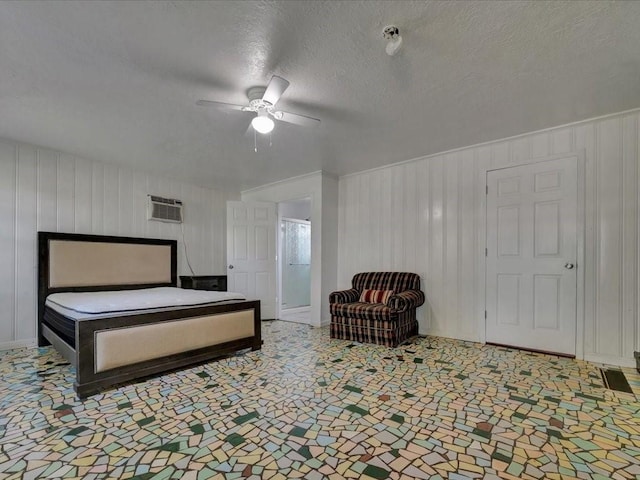 bedroom featuring ceiling fan, a wall mounted air conditioner, and a textured ceiling