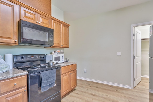 kitchen featuring light wood-type flooring and black appliances