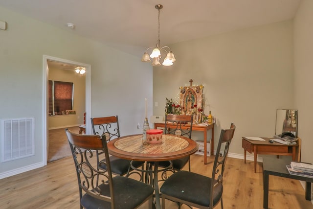 dining area featuring light hardwood / wood-style floors and a notable chandelier