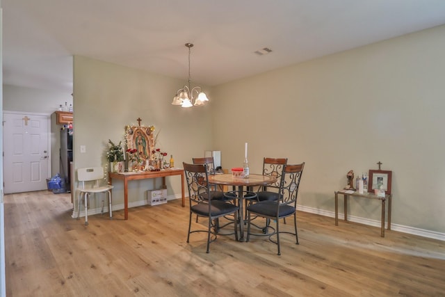 dining room with an inviting chandelier and light hardwood / wood-style floors