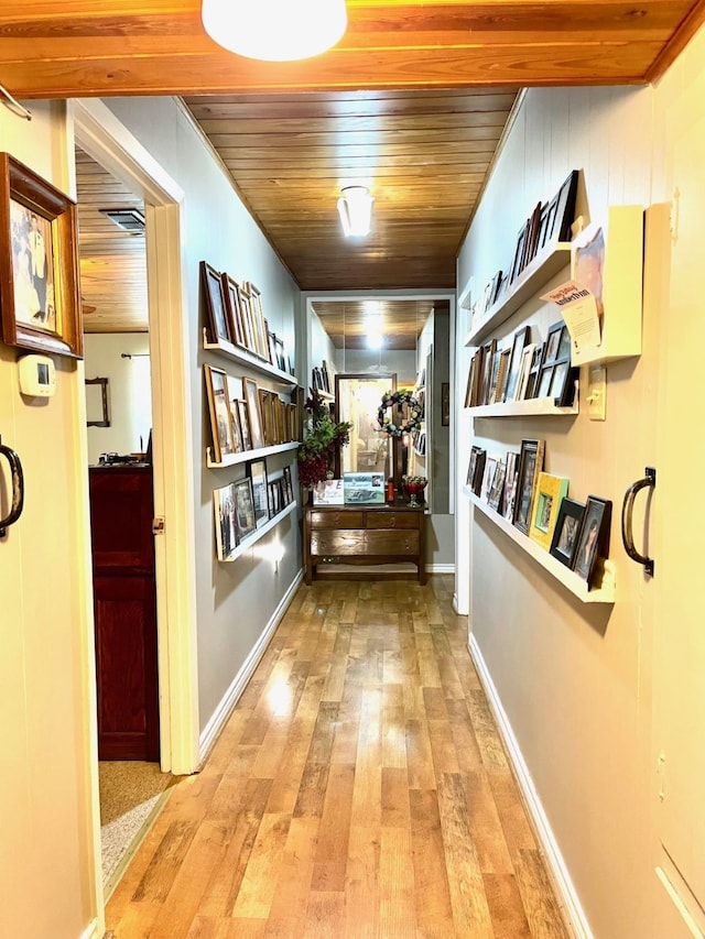 hall featuring wood ceiling, crown molding, and light hardwood / wood-style flooring