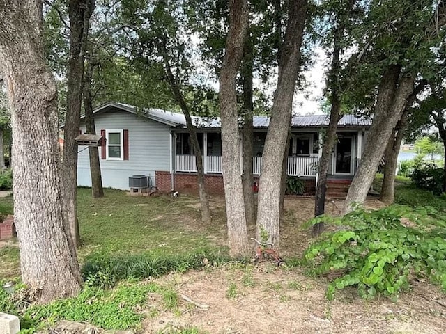 view of front of property with central air condition unit and a front lawn