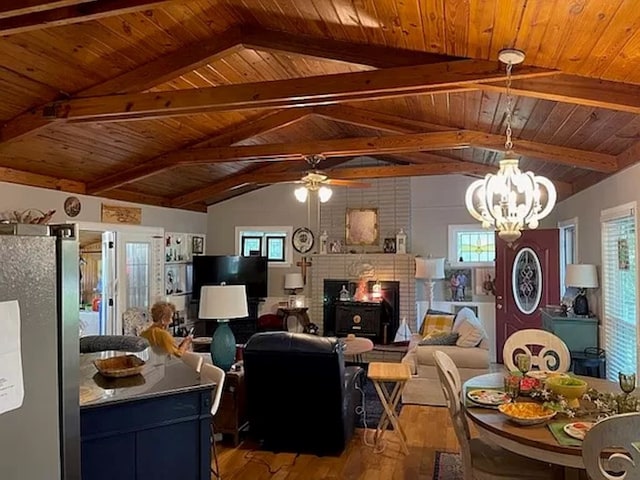 living room with lofted ceiling with beams, a fireplace, hardwood / wood-style flooring, and plenty of natural light