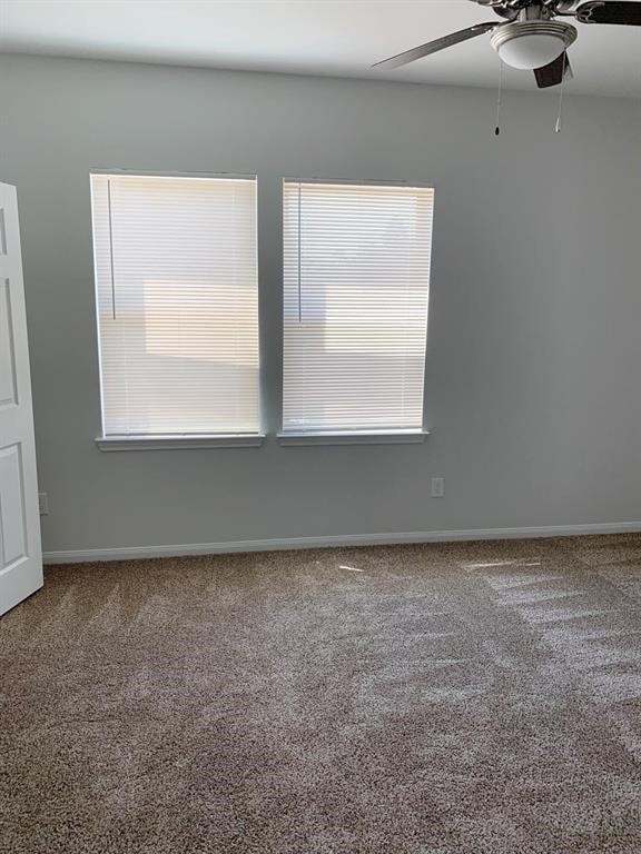 unfurnished room featuring carpet flooring, a wealth of natural light, and ceiling fan