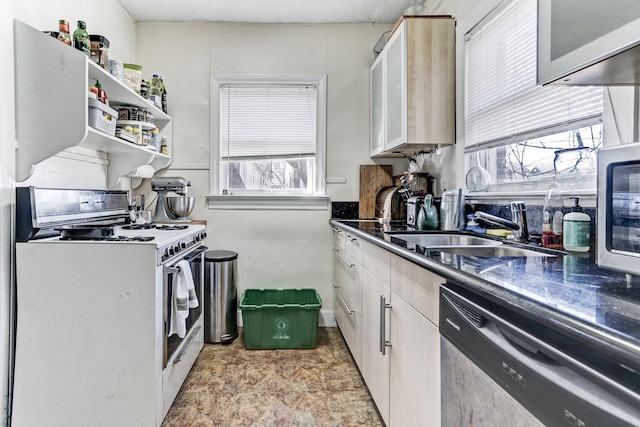 kitchen with white cabinets, white gas stove, dishwasher, and sink