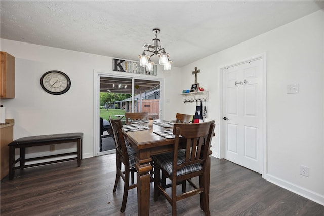 dining space featuring dark hardwood / wood-style flooring, a chandelier, and a textured ceiling