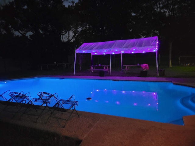 view of pool at twilight