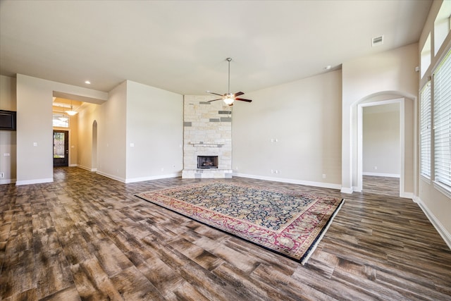 unfurnished living room featuring ceiling fan, dark hardwood / wood-style flooring, and a fireplace