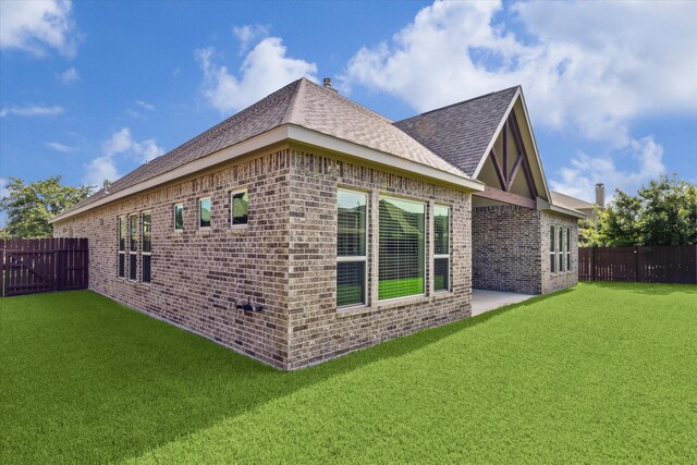 view of side of home featuring a patio and a yard