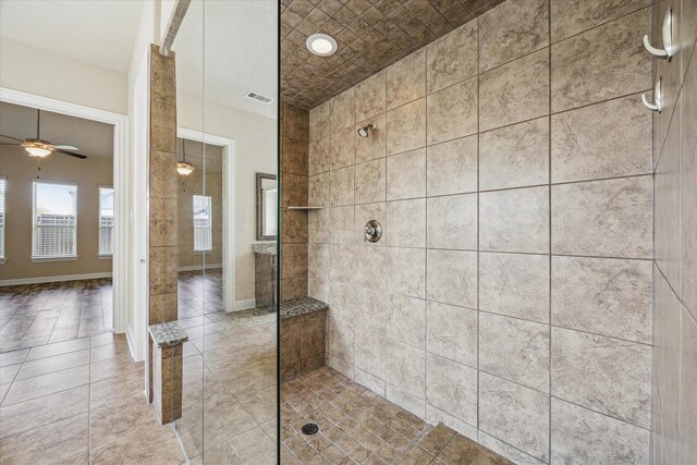 bathroom featuring a tile shower, ceiling fan, and tile floors