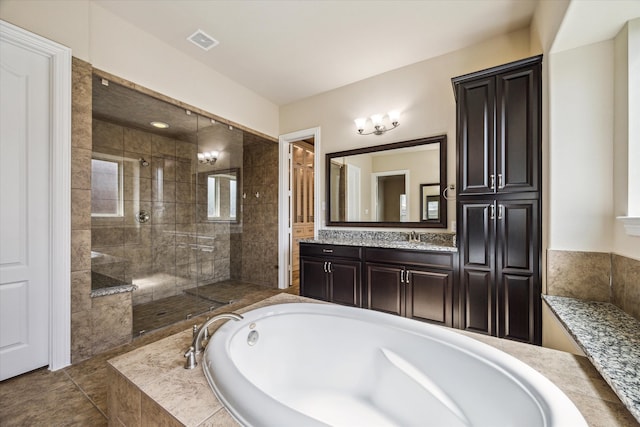 bathroom featuring tile flooring, shower with separate bathtub, and vanity