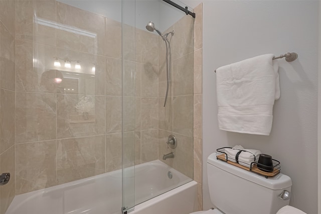 bathroom featuring combined bath / shower with glass door and toilet