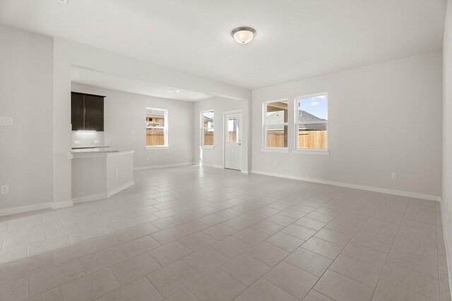 unfurnished room featuring light tile patterned floors and a wealth of natural light