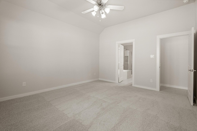 empty room featuring ceiling fan, light carpet, and vaulted ceiling