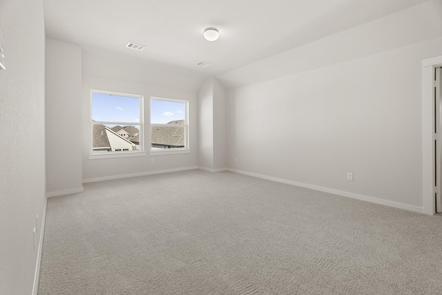 carpeted spare room with lofted ceiling