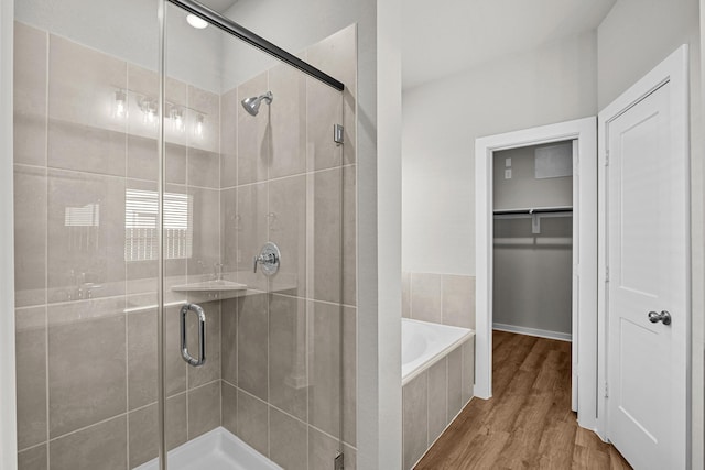 bathroom with hardwood / wood-style floors and independent shower and bath