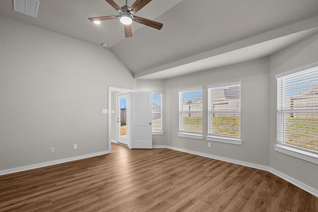 spare room with lofted ceiling, plenty of natural light, hardwood / wood-style floors, and ceiling fan