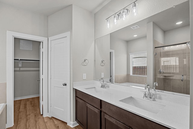 bathroom featuring walk in shower, wood-type flooring, and vanity