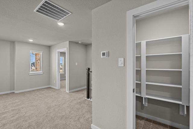 interior space with light carpet and a textured ceiling