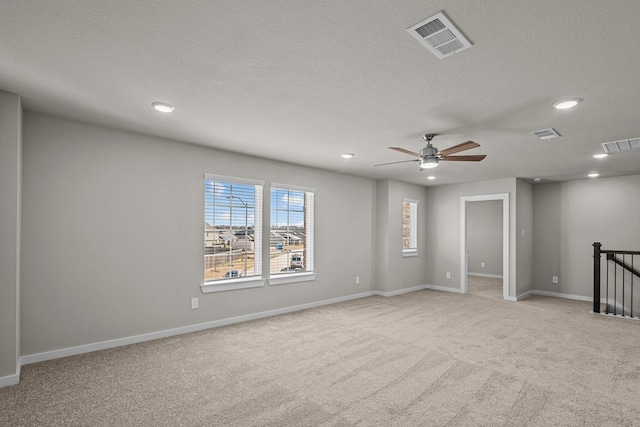 carpeted spare room with ceiling fan and a textured ceiling