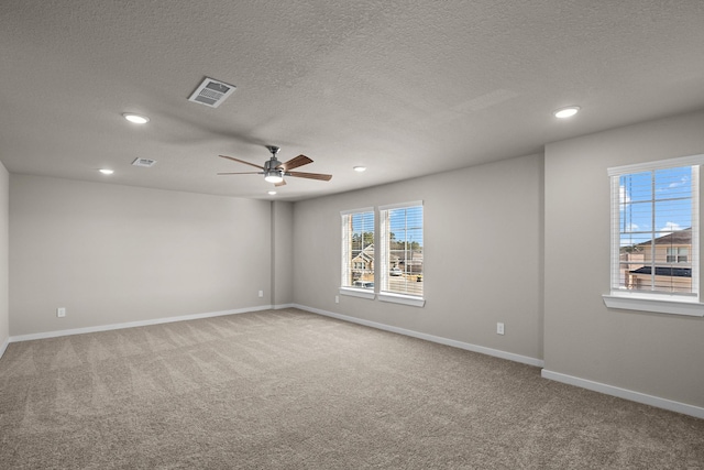 spare room with ceiling fan, carpet flooring, and a textured ceiling