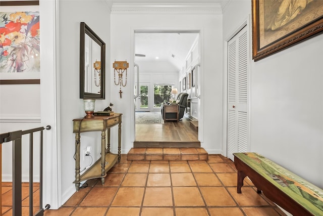 hallway with tile patterned floors and crown molding