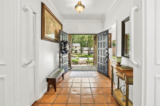 tiled entrance foyer featuring crown molding