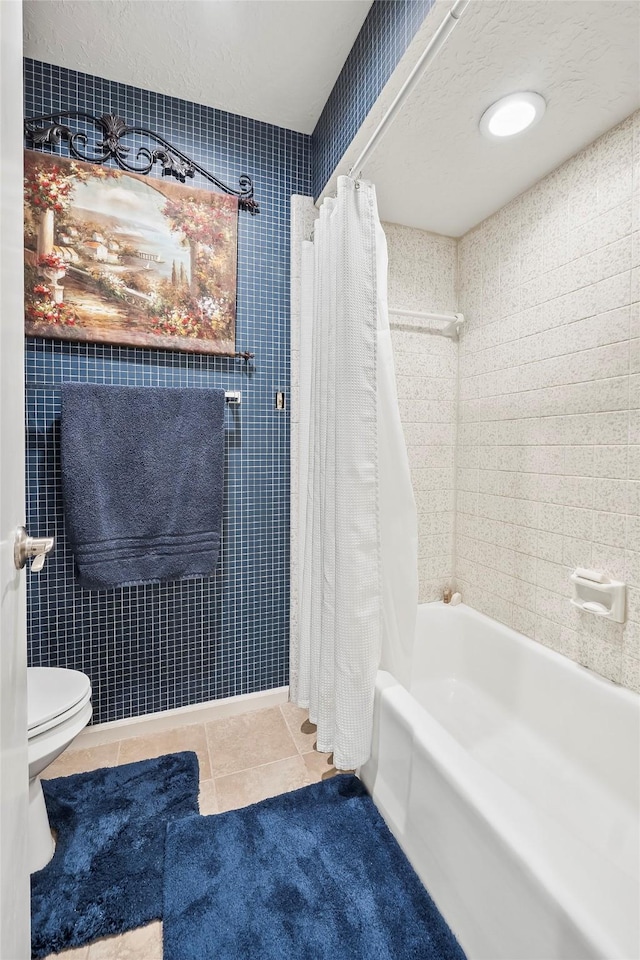 bathroom with toilet, tile patterned floors, and shower / bath combo with shower curtain