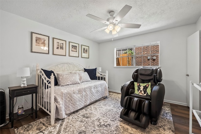 bedroom with a textured ceiling, dark hardwood / wood-style floors, and ceiling fan