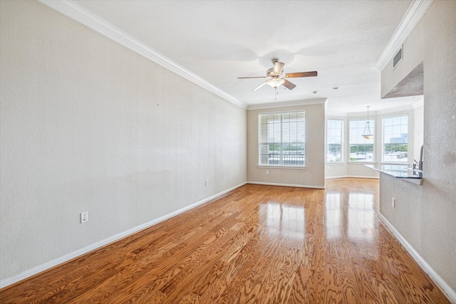 unfurnished living room with light hardwood / wood-style floors, ceiling fan, and ornamental molding