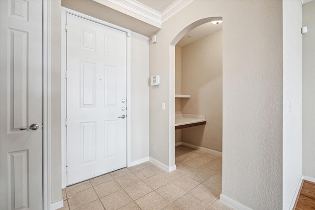 entrance foyer with crown molding and light tile patterned flooring