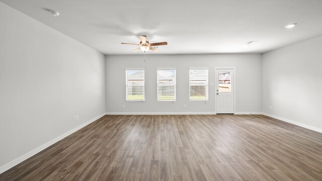 unfurnished room with ceiling fan and dark wood-type flooring