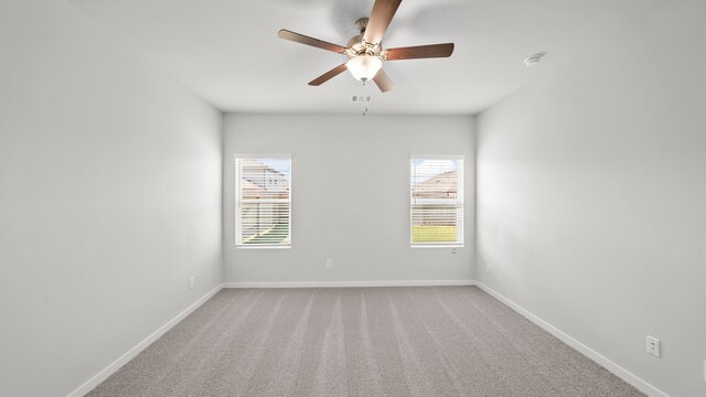 carpeted spare room featuring ceiling fan