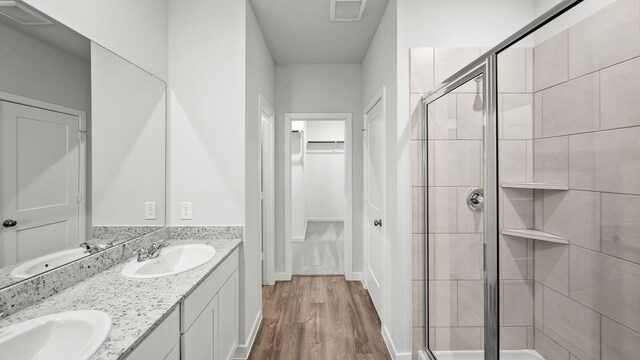 bathroom featuring an enclosed shower, vanity, and hardwood / wood-style floors