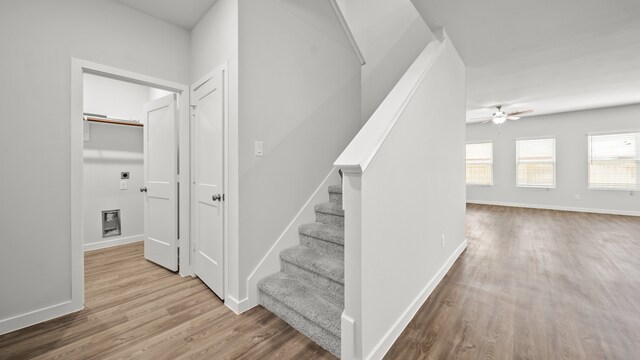 stairs with ceiling fan and hardwood / wood-style flooring