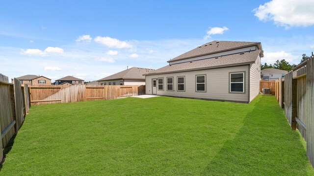 rear view of property with a lawn and central AC unit