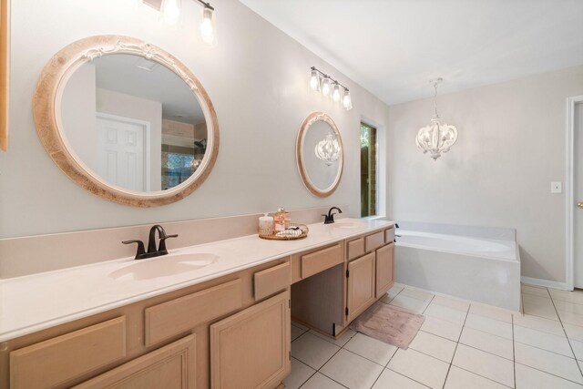 bathroom with an inviting chandelier, double vanity, tile floors, and a bathing tub