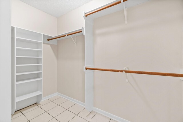 walk in closet featuring light tile floors