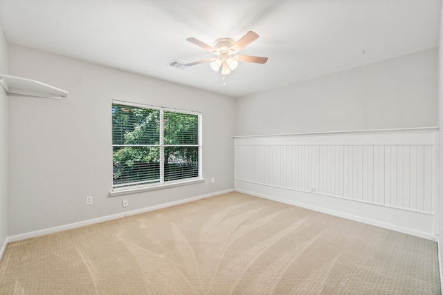 empty room featuring ceiling fan and light colored carpet