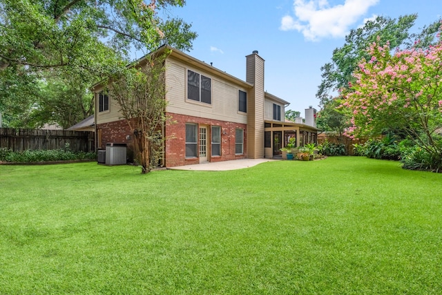 rear view of house featuring a patio area, central AC, and a lawn