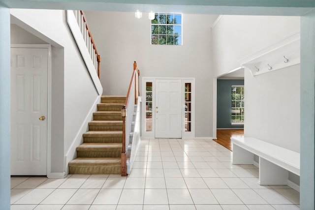 entrance foyer with a high ceiling, light tile floors, and rail lighting