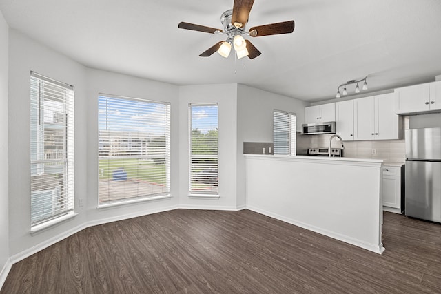 kitchen featuring white cabinets, backsplash, dark hardwood / wood-style flooring, and stainless steel appliances