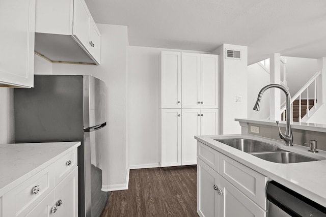 kitchen featuring white cabinetry, sink, light stone countertops, dark hardwood / wood-style flooring, and appliances with stainless steel finishes