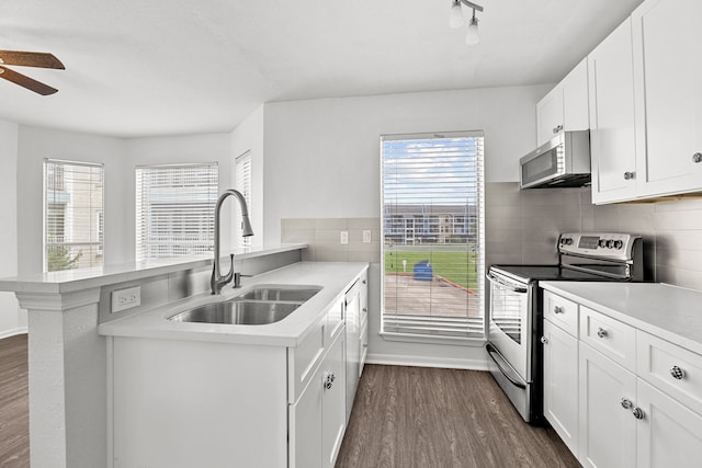 kitchen with white cabinetry, sink, kitchen peninsula, and stainless steel appliances