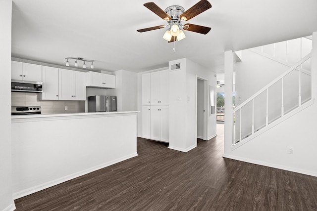 kitchen featuring white cabinets, ceiling fan, decorative backsplash, appliances with stainless steel finishes, and dark hardwood / wood-style flooring